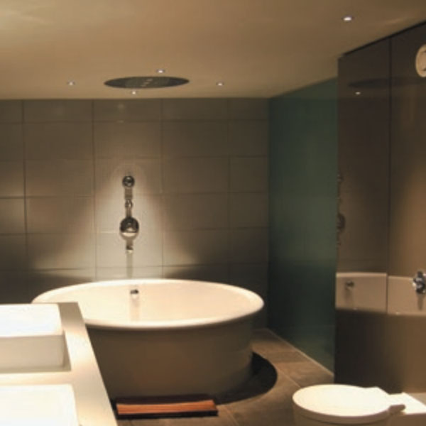 Recessed LED downlights lighting up bath tub in tiled bathroom