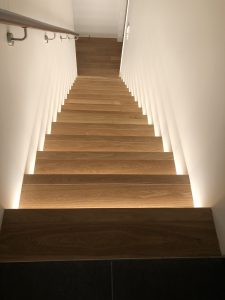 View from top of the stair case looking down. The stairs are illuminated from underneath using LED striplights recessed into stair risers.